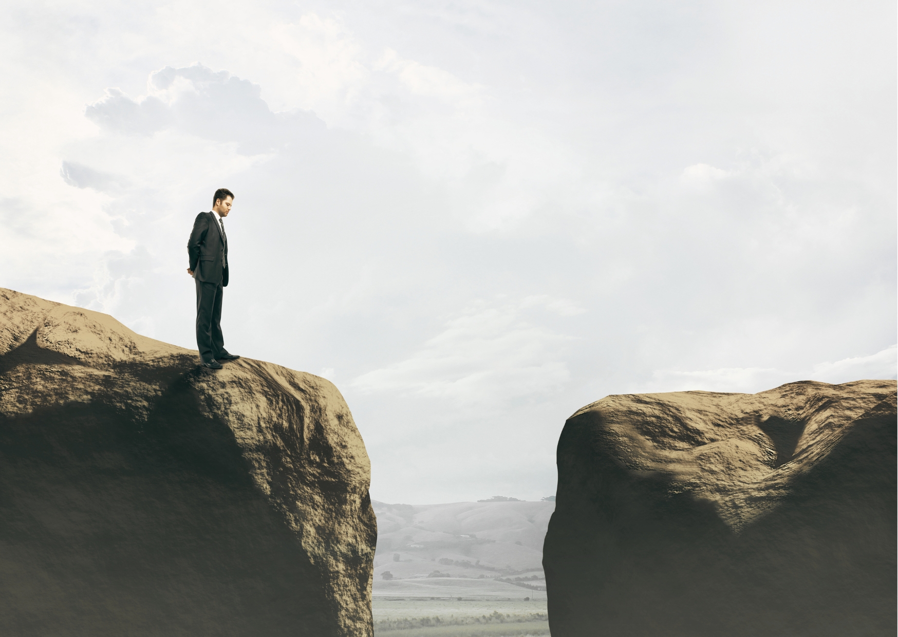 Delivery leader looking across a mountain gap, representing the need to understand AI capability gaps before hiring.