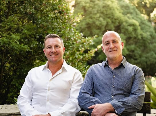 Two Acuity Consultants team members seated outdoors