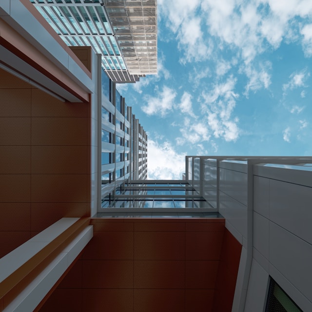 Upward view between modern office buildings representing DevOps and cloud infrastructure