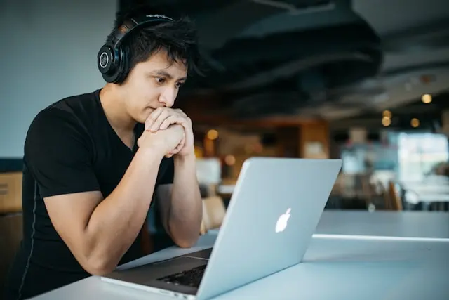 Software Engineer wearing headphones while working independently on a laptop