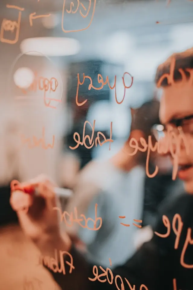 Professional writing project notes on a glass board during a planning session