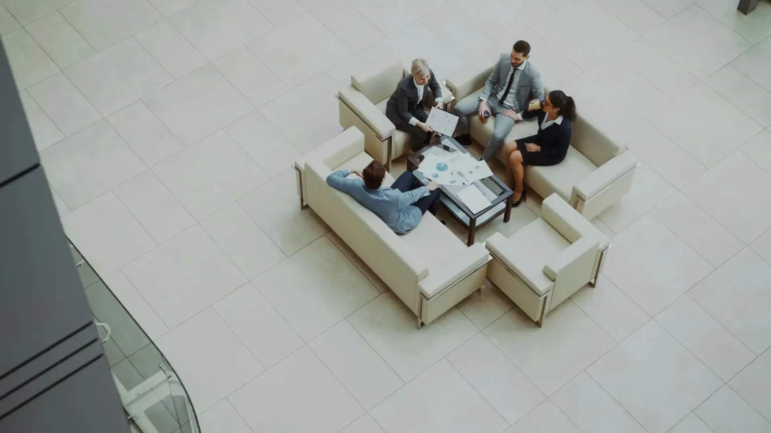 four business professionals sitting on couches and talking