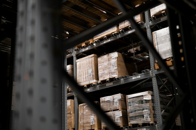 Warehouse pallet racking seen through steel framing, the kind of supply chain operation an ERP system runs