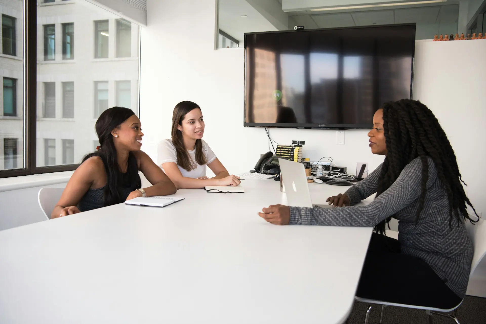 Three colleagues discussing a workforce plan in a boardroom meeting