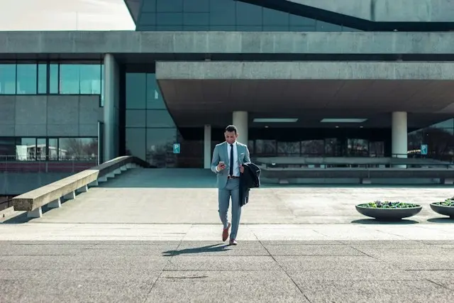 Senior executive walking outside a corporate office building, representing leadership departures and executive resignation risks.