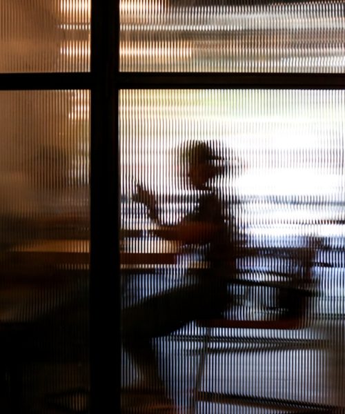 Single executive leader sitting behind a glass office door